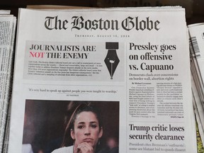 The front page of the  Aug. 16, 2018 edition of the Boston Globe reads "Journalists are not the enemy" as it sits for sale at Out of Town News in Cambridge, Mass.