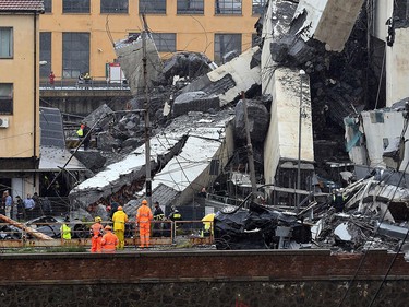 Rescuers scour through the rubble and wreckage after a giant motorway bridge collapsed earlier in Genoa on Aug. 14, 2018.