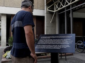 A second plaque has been installed to replace a bronze statue of Canada's first Prime Minister Sir John A. Macdonald after it was vandalized shortly after the removal of the statue over the weekend. People walk by the plaque daily as it stands in front of City Hall Victoria, B.C., on Tuesday, August 14, 2018. THE CANADIAN PRESS/Chad Hipolito