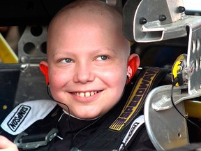 In this Saturday, Aug. 18, 2018, photo, Caleb Hammond, an 11-year-old Iowa boy who wants racing stickers to cover his casket after he dies from leukemia, grins before heading out in a stock car designed for children on the Southern Iowa Speedway dirt track in Oskaloosa, Iowa.