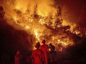 Firefighters monitor a backfire while battling the Ranch Fire, part of the Mendocino Complex Fire near Ladoga, Calif., on Aug. 7, 2018.