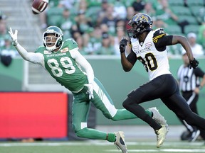 Saskatchewan Roughriders wide receiver Duron Carter attempts a one handed interception against the Hamilton Tiger-Cats wide receiver Terrence Toliver during first half CFL action in Regina on July 5, 2018.