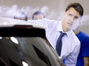 Prime Minister Justin Trudeau uses a smoke wand during a demonstration of air flow over a car during a visit to the University of Ontario's Institute of Technology in Oshawa, Ont. on Friday Aug. 31, 2018.