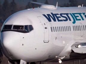 A pilot taxis a Westjet Boeing 737-700 plane to a gate after arriving at Vancouver International Airport in Richmond, B.C., on Monday, February 3, 2014.