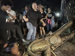 Protesters celebrate after the Confederate statue known as "Silent Sam" was toppled on the campus of the University of North Carolina in Chapel Hill, N.C., Monday, Aug. 20, 2018.