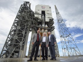 In this photo provided by NASA, astrophysicist Eugene Parker, centre, stands with NASA Associate Administrator for the Science Mission Directorate Thomas Zurbuchen, left, and United Launch Alliance President and Chief Executive Officer Tory Bruno in front of the ULA Delta IV Heavy rocket with NASA's Parker Solar Probe onboard, Friday, Aug. 10, 2018 at Cape Canaveral Air Force Station, Fla.