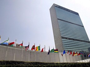 The flags of member nations fly outside the General Assembly building at the United Nations headquarters in New York on September 13, 2005. The federal government is reviewing a decision of the UN Human Rights Council saying Canada violated the rights of a woman living in Canada as an undocumented irregular migrant when she was denied health coverage under the Interim Federal Health Program. As part of its non-binding ruling, the UN committee says Canada has an onus to provide the woman with compensation for harm she suffered after developing serious health conditions that required medical treatment.