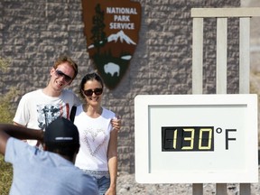 A couple poses at the Furnace Creek Visitor Center thermometer in Death Valley National Park, Calif., on  July 26, 2018. The thermometer is not official and often very inaccurate, but is a popular photo spot.