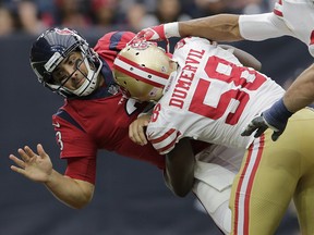 Tom Savage of the Houston Texans is hit by Elvis Dumervil of the San Francisco 49ers at NRG Stadium on December 10, 2017 in Houston. (Tim Warner/Getty Images)