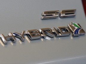 This Feb. 14, 2013, file photo shows a hybrid logo on the back of a Ford Fusion hybrid automobile at the 2013 Pittsburgh Auto Show in Pittsburgh. (AP Photo/Gene J. Puskar, File)