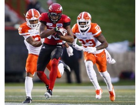 BC Lions' Otha Foster III, left, and Anthony Thompson, right, chase Calgary Stampeders' Kamar Jorden, during second half CFL football action in Calgary, Saturday. Photo byJeff McIntosh/The Canadian Press