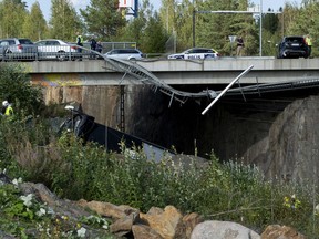 The wreckage of a bus lays across railway tracks after crashing in Kuopio, central Finland Friday Aug. 24, 2018.