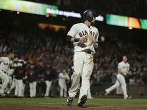 San Francisco Giants' Steven Duggar crosses home plate to score as his teammates rush to greet Gorkys Hernandez after he hit a walk-off single against Jake Diekman in the ninth inning of a baseball game, Tuesday, Aug. 28, 2018, in San Francisco.