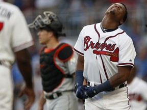 Atlanta Braves' Ronald Acuna Jr., right, reacts after being hit by a pitch from Miami Marlins' Jose Urena Wednesday, Aug. 15, 2018 in Atlanta.