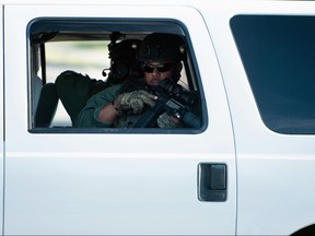 A member of the Palm Beach County Sheriff's SWAT team watches while escorting a motorcade with U.S. President Donald Trump to the Trump International Golf Club on March 25, 2018 in West Palm Beach, Florida.