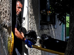 A policeman carries one of the corpses found at a clandestine grave inside a house in Guadalajara, Jalisco State, Mexico on Aug. 3, 2018.