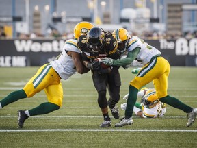 Hamilton Tiger-Cats’ head coach June Jones likes all his options at running back, but prefers to find the hot hand and stick with it. Lately, that has been Alex Green (centre) and he’s more than happy to carry the load.(The Canadian Press)