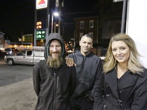 In this Nov. 17, 2017, file photo, Johnny Bobbitt Jr., left, Kate McClure, right, and McClure's boyfriend Mark D'Amico pose at a Citgo station in Philadelphia.  McClure and D'Amico, who raised more than $400,000 for Bobbitt Jr., a homeless man after he used his last $20 to fill up the gas tank of a stranded motorist in Philadelphia must now turn over what's left of the cash. A New Jersey judge issued the order Thursday, Aug. 30,  during a hearing on the lawsuit brought by Bobbitt, who worries D'Amico and McClure have mismanaged a large part of the donations raised for him on GoFundMe. The couple deny those claims, saying they're wary of giving Bobbitt large sums because they fear he would buy drugs.