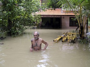 An elderly man wades through flood waters to reach a boat carrying food supplies for stranded people in Chengannur in the southern state of Kerala, India, Sunday, Aug.19, 2018. (AP Photo/Aijaz Rahi)