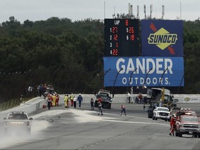 Track workers repair a section of fence after a wreck during the IndyCar race at Pocono Raceway,  in Long Pond, Pa., Sunday, Aug. 19, 2018.