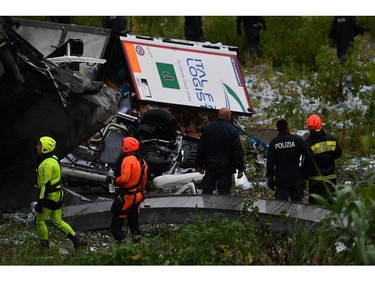 Rescues work among the debris of the collapsed Morandi highway bridge in Genoa, Tuesday, Aug. 14, 2018.