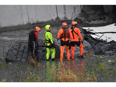 Rescuers work among the rubble of the collapsed Morandi highway bridge in Genoa, northern Italy, Tuesday, Aug. 14, 2018.