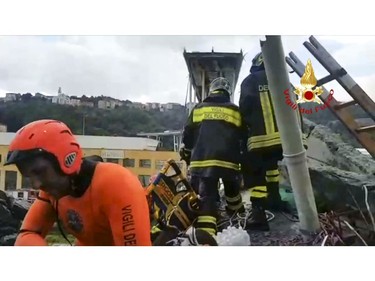 This frame taken from a video released by the Italian firefighters, shows firefighters working on the site of the collapsed Morandi highway bridge in Genoa, northern Italy, Tuesday, Aug. 14, 2018.