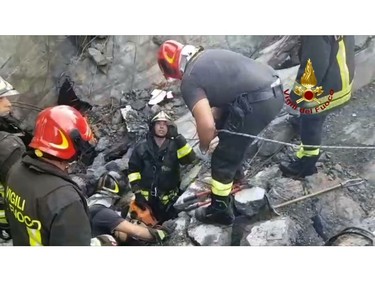 This frame taken from a video released by the Italian firefighters, shows firefighters working on the site of the collapsed Morandi highway bridge in Genoa, northern Italy, Tuesday, Aug. 14, 2018.