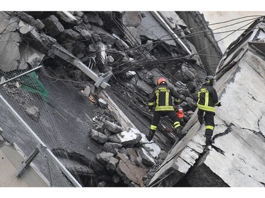 Rescues work among the rubble of the collapsed Morandi highway bridge in Genoa, northern Italy, Tuesday, Aug. 14, 2018.