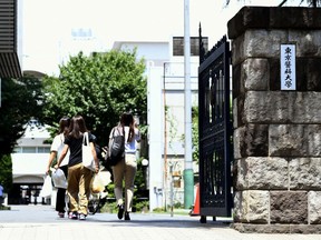 People walk into the Tokyo Medical University Thursday, Aug. 2, 2018, in Tokyo. (AP Photo/Ayaka Aizawa)