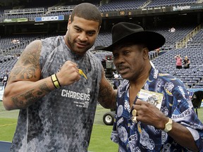 In this Oct. 3, 2010, file photo, San Diego Chargers linebacker Shawne Merriman, left, poses with boxing legend Joe Frazier before playing the Arizona Cardinals in San Diego. (AP Photo/Gregory Bull, File)