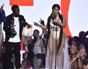 Nicki Minaj, right, accepts the award for best hip-hop video for "Chun-Li" as presenter Kevin Hart looks on at the MTV Video Music Awards at Radio City Music Hall on Monday, Aug. 20, 2018, in New York. (Chris Pizzello/Invision/AP)