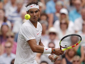 Rafael Nadal returns the ball to Novak Djokovic in the men's singles semifinal at Wimbledon , in London, Saturday July 14, 2018. (THE CANADIAN PRESS/AP-POOL, Andrew Couldridge)