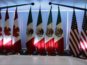 National flags representing Canada, Mexico, and the U.S. are lit by stage lights at the North American Free Trade Agreement, NAFTA, renegotiations, in Mexico City, Tuesday, Sept. 5, 2017.