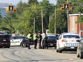 Police officers survey the area of a shooting in Fredericton, N.B. on Friday, August 10, 2018.