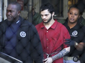 Esteban Santiago, center, is led from the Broward County jail for an arraignment in federal court in Fort Lauderdale, Fla., on Jan. 30, 2017.