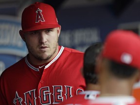 Los Angeles Angels' Mike Trout stands in the dugout during the third inning of a baseball game against the Cleveland Indians, Saturday, Aug. 4, 2018, in Cleveland.
