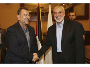 Ismail Haniyeh, right, the head of the Hamas political bureau, shakes hands with his deputy Saleh Arouri upon his arrival in Gaza from Cairo, Egypt, in Gaza City, Thursday, Aug. 2, 2018. (Mohammad Austaz/Hamas Media Office via AP)