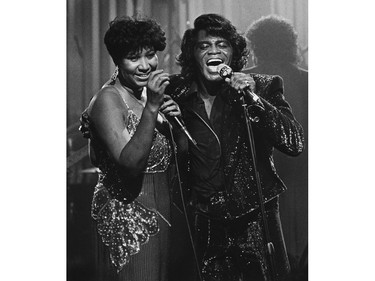 In this Jan. 11, 1987 file photo, soul singers James Brown and Aretha Franklin sing during a Home Box Office taping at the Taboo night club in Detroit.