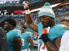 Dolphins defensive end Robert Quinn raises his right fist during the singing of the national anthem, before the team's preseason game against the Buccaneers, Thursday, Aug. 9, 2018, in Miami Gardens, Fla.