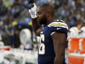 Chargers offensive tackle Russell Okung raises his fist during the playing of the U.S. anthem before the team's preseason game against the Seahawks in Carson, Calif., Saturday, Aug. 18, 2018.