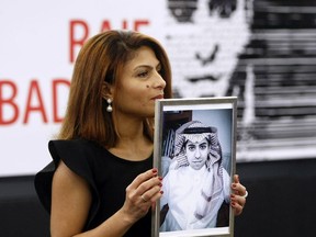 FILE - In this Dec, 16, 2015 file photo, Ensaf Haidar, wife of the jailed Saudi Arabian blogger Raif Badawi, shows a portrait of her husband as he is awarded the Sakharov Prize, in Strasbourg, France. Saudi Arabia has given Canada's ambassador 24 hours to leave the kingdom after Canada criticized the recent arrest of women's rights activists. Among the arrested activists is Samar Badawi, whose writer brother Raif Badawi was arrested in Saudi Arabia in 2012 and later sentenced to 1,000 lashes and 10 years in prison for insulting Islam while blogging.