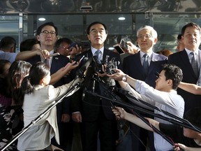 South Korean Unification Minister Cho Myoung-gyon, center, speaks to the media before leaving for the border village of Panmunjom to attend a meeting between South and North Korea, at the Office of the South Korea-North Korea Dialogue in Seoul, South Korea, Monday, Aug. 13, 2018.