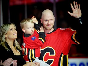 Matt Stajan, with his with Katie and son Elliot, during a ceremony honouring the Flames forward for playing in 1,000 games. (Al Charest/Postmedia)