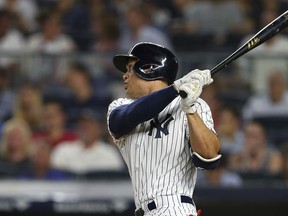 New York Yankees' Giancarlo Stanton watches his two-run home run during the third inning against the Detroit Tigers during a baseball game Thursday, Aug. 30, 2018, at Yankee Stadium in New York. It was Stanton's 300th career home run.
