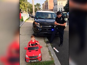 In this July 31, 2018 photo, Grayson Salerno, 1, is pulled over for driving without a license, but he got off with a "cuteness warning" in Malden, Mass.