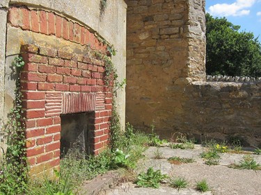 This July 8, 2018 photo, shows the remains of a fireplace and a missing window, in a ruined cottage in Tyneham, in Dorset, England. The village was commandeered by the military in 1943 and the people evacuated. They were never allowed back and Tyneham remains in the hands of the Ministry of Defense. The village dwellings have slowly fallen apart, as waether rotted the roof beams and upper floors and nature reclaimed the interiors.