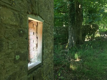 In this July 8, 2018 photo, light pours through the empty window frame of a ruined cottage, in Tyneham, England's "ghost village." All the homes in the tiny settlement have fallen apart since it was taken over by the military at the height of World War II, to provide more land for D-Day training. Tyneham is still in the hands of the Ministry of Defense, but visitors are allowed in most weekends.
