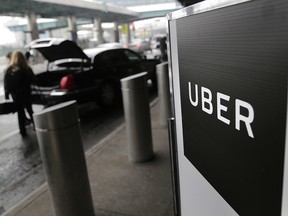 In this March 15, 2017 file photo, a sign marks a pick-up point for the Uber car service at LaGuardia Airport in New York. (AP Photo/Seth Wenig, File)