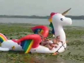 ‏A video screengrab of women stranded on a rainbow unicorn raft in Fish Lake, Minn.